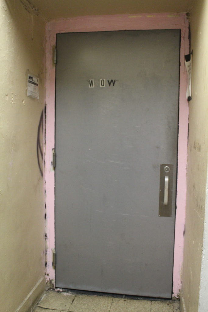 une porte grise dans un couloir vétuste